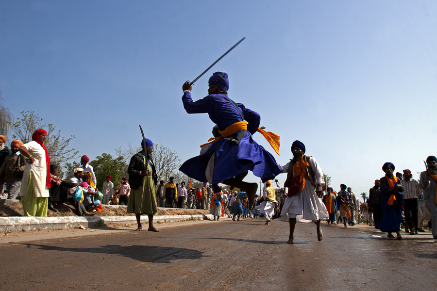 nihang sikh warrior displaying his martial art skill with sword at hola mohalla at anandpur sahab in punjab.