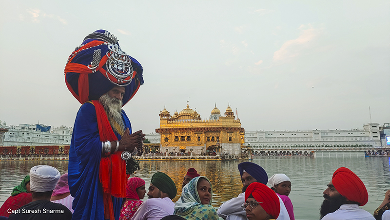 nihang singh warrior in traditional attire represents sikh culture at golden temple on gurupurab amritsar india.