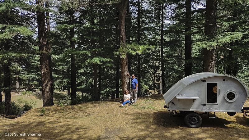a couple enjoying romantic holidays with caravan campervan dharamshala palampur mcleodganj himachal for offbeat outdoor camp corona safe with social distancing india.