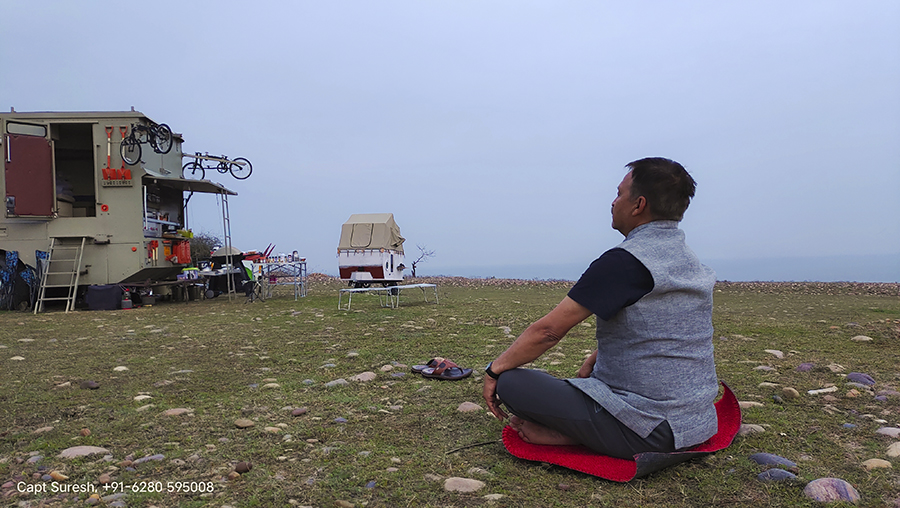 a guest at camp with caravan and campervan is enjoying a session of yoga and meditation in the wilderness in the lap of mother nature in a quiet place around pong dam in himachal pradesh.